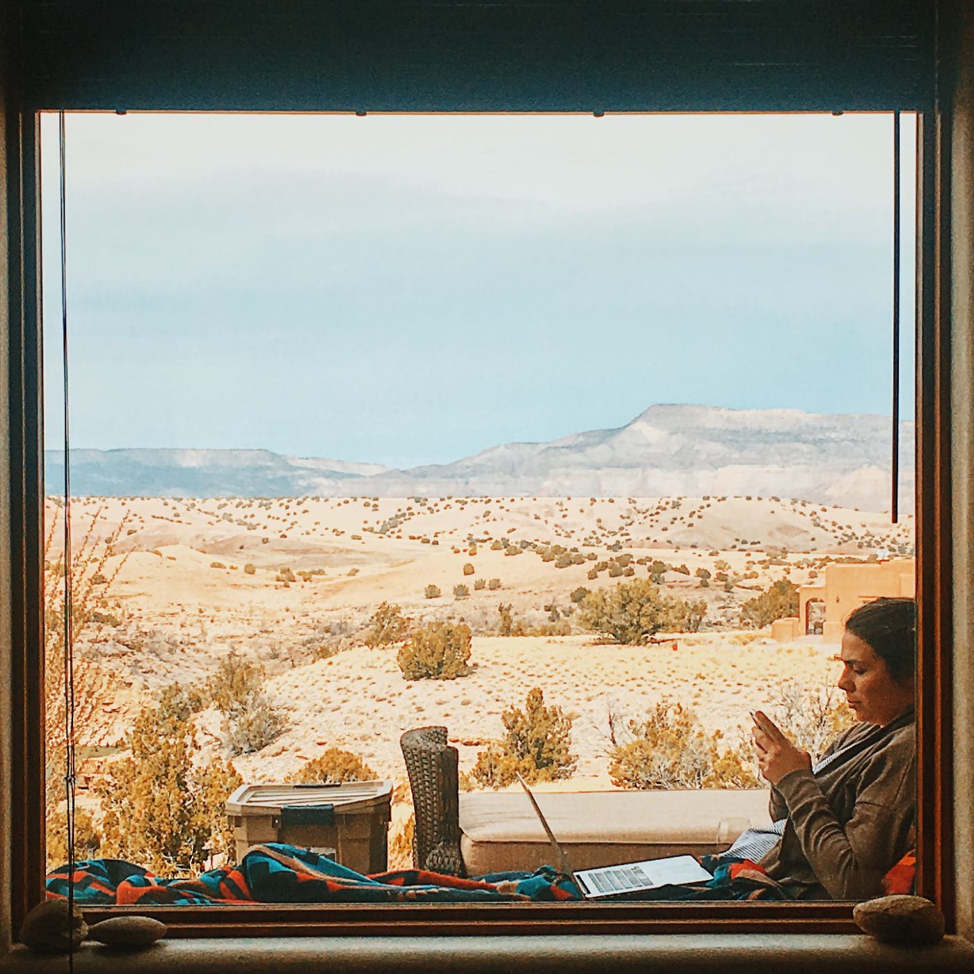 reading by a window over the desert