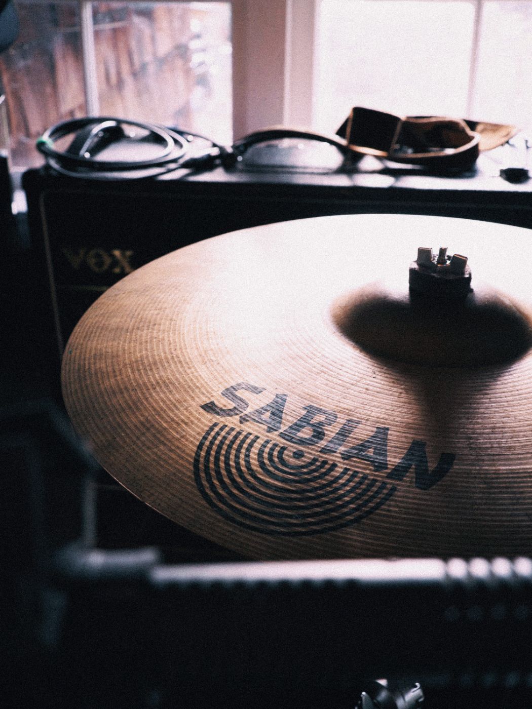 a cymbal and amp by the studio window